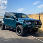Green Volkswagen Amarok with bullbar and Canna Fabrication short-entry stainless snorkel — front three-quarter view