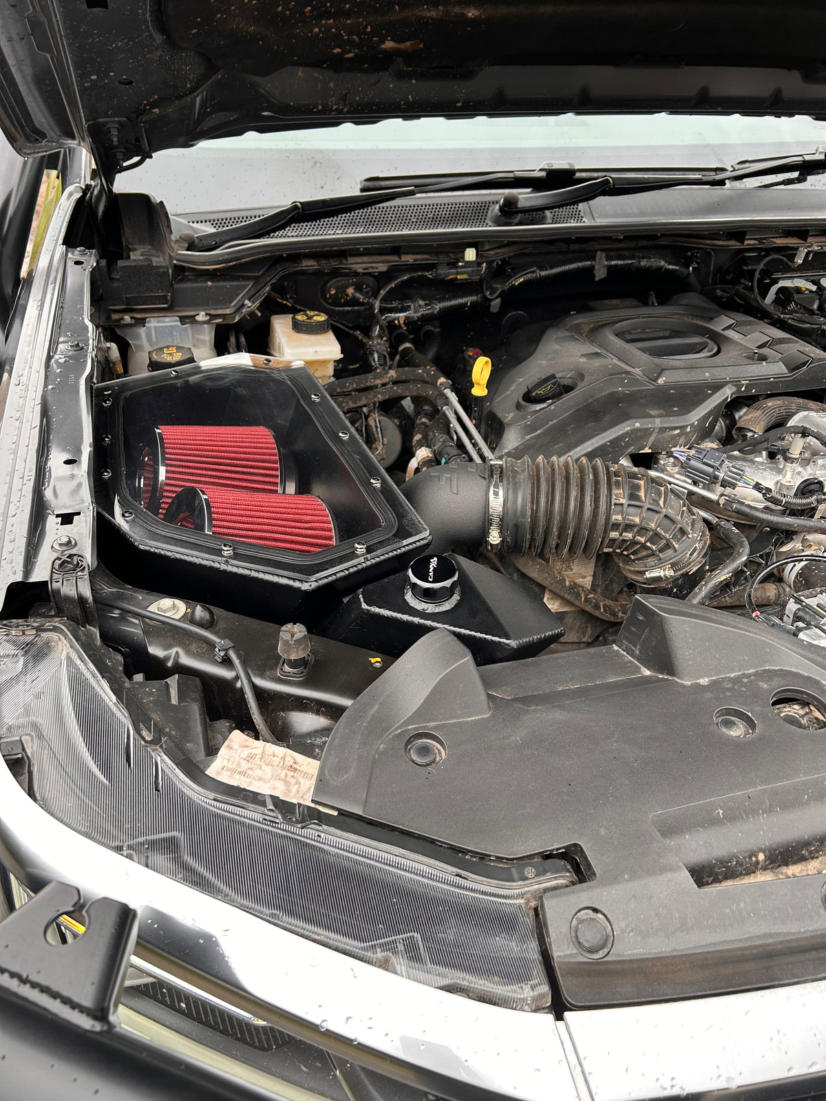 Canna Fabrication aftermarket airbox with red pod filter installed in a 4WD engine bay